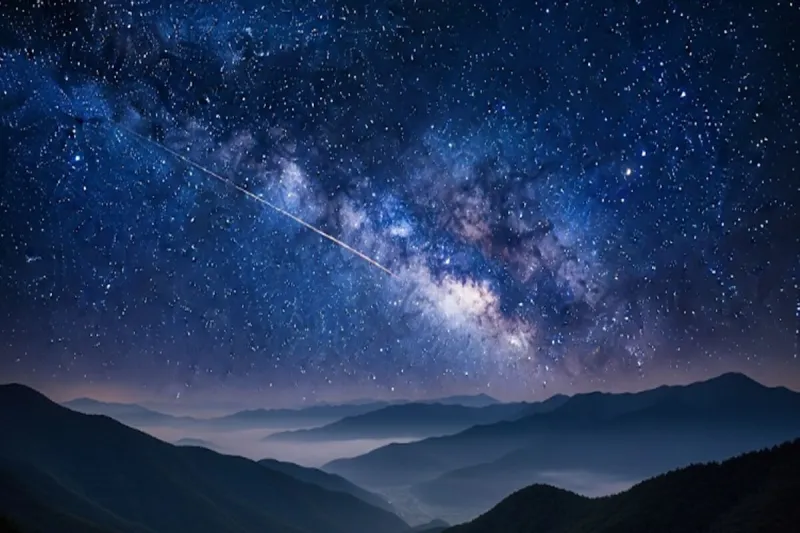 고요한 한국의 산맥 위로 은하수가 펼쳐진 밤하늘을 가로지르는 밝은 유성