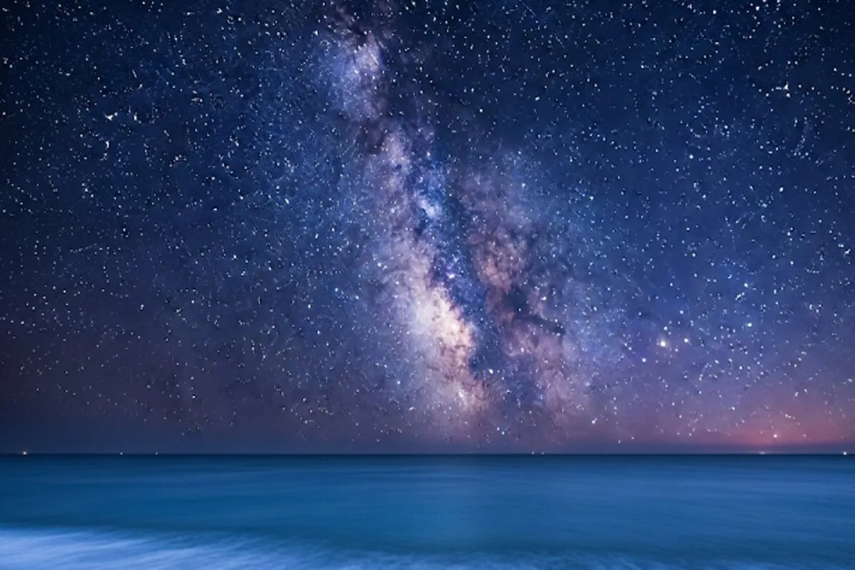 고요한 한국의 여름 밤바다 위로 은하수를 가로지르며 밝게 빛나는 여름의 대삼각형(베가, 데네브, 알타이르)